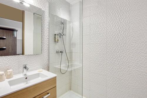 a white bathroom with a shower and a sink at Best Western H&ocirc;tel Agen Le Passage, Agen Sud in Le Passage