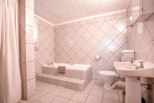 a bathroom with a toilet and a sink at Trennerys Hotel in Qolora Mouth