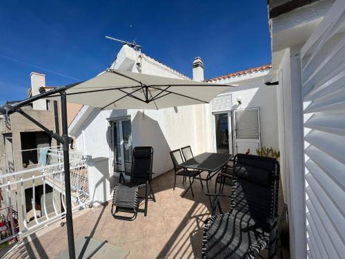 a patio with a table and chairs and an umbrella at Apartments Toni in Podstrana