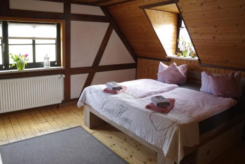 a bedroom with a bed in a attic with windows at Wirtschaft & Pension Zum Huthaus in Schneeberg