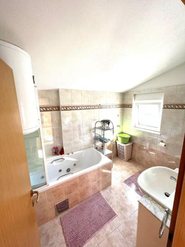 a large bathroom with a tub and a sink at Apartments Toni in Podstrana