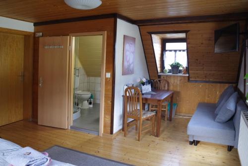 ein kleines Zimmer mit einem Tisch und einem Badezimmer. in der Unterkunft Wirtschaft & Pension Zum Huthaus in Schneeberg