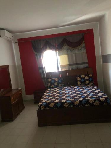um quarto com uma cama grande e uma janela em Al Rayane em Dakar
