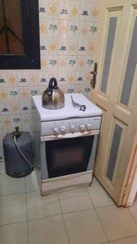 uma cozinha com um fogão e uma chaleira. em Al Rayane em Dakar