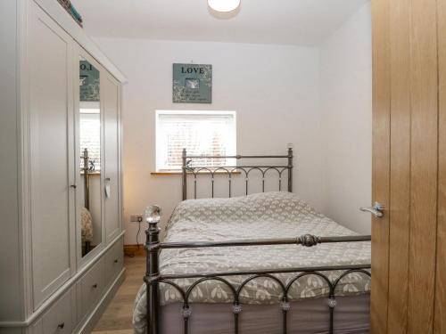 - une chambre avec un lit en métal et une fenêtre dans l'établissement Primose Cottage, à Cromer