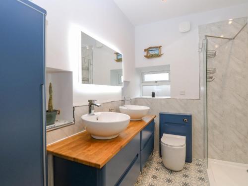 a bathroom with two sinks and a shower at Primose Cottage in Cromer