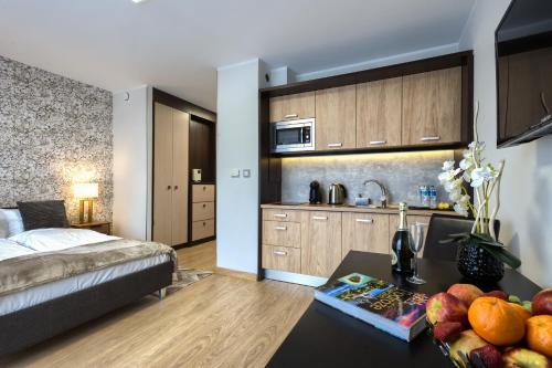 a bedroom with a bed and a table with fruit on it at Alibi Apartments in Wrocław