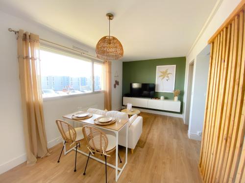 un salon avec une table et des chaises blanches dans l'établissement Le Studio Calaisien, à Calais