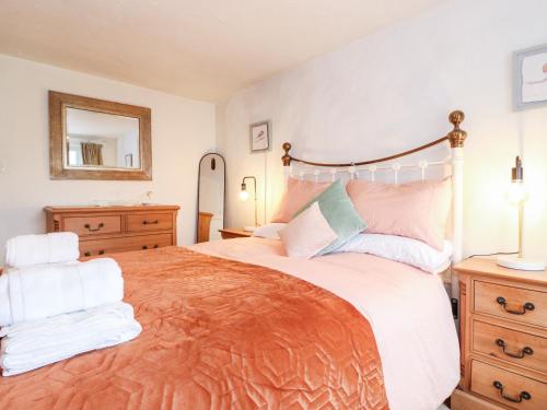 a bedroom with a large bed and a mirror at Meadow Cottage in Kendal