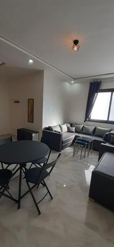 una sala de estar con sofás, mesas y sillas en Chez Franck, en Saidia 