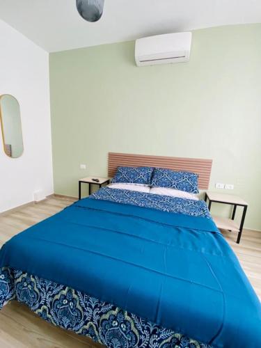a large blue bed in a white room at Arabesque Hotel in Amman