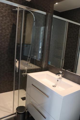 W łazience znajduje się biała umywalka i prysznic. w obiekcie "Le 104" studio cosy proche de Rouen avec parking w mieście Mont-Saint-Aignan
