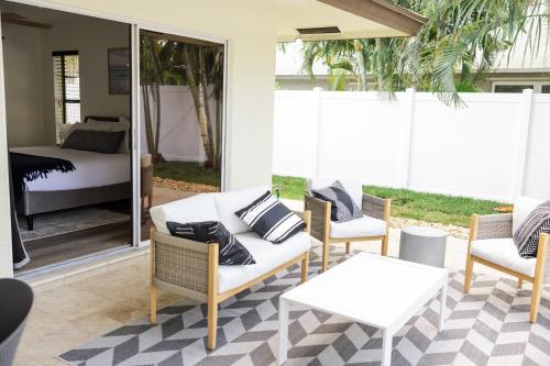 a patio with a couch and two chairs and a bed at Blu Sky Villa in Boynton Beach