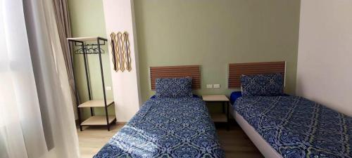 a bedroom with two beds and a table with a lamp at Arabesque Hotel in Amman