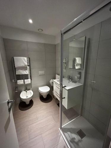a bathroom with a toilet and a sink and a shower at Fasthotel Linate in Segrate
