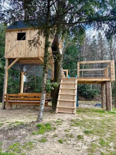 a tree house with a staircase next to a tree at Villa Vincentów in Myślenice