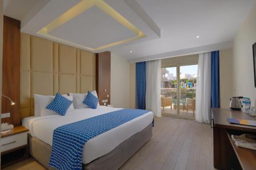 a bedroom with a large bed with blue pillows at Bellagio Beach Resort & Spa in Hurghada