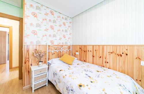een slaapkamer met een bed en een houten muur bij Casa Morana Apartamento con garaje in Zamora