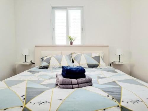 a bedroom with a large bed with a blue bag on it at "In the heart of Acre" from Shneider Apartments in Acre