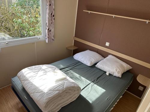 聖喬治德迪東的住宿－Mobilhome 6 personnes，一张位于房间的床,上面有两个枕头