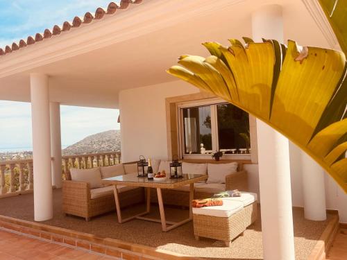 patio con mesa y sillas en el balcón en Denia Dream Seaview Golf, Tennis & Beach Villa, en Muntanya la Sella