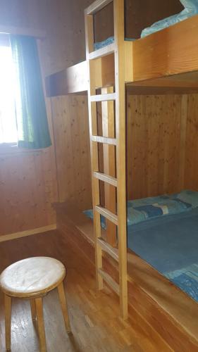 een slaapkamer met een stapelbed met een kruk en een stoel bij Skihütte Obererbs in Elm