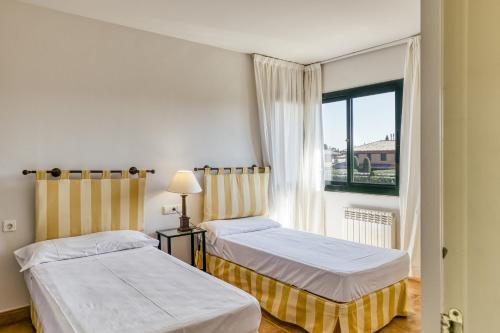 2 camas en una habitación con ventana en Family villa in Torremirona Resort, en Navata
