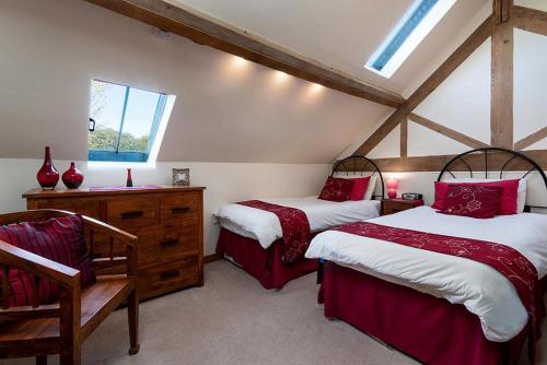 a bedroom with two beds and a chair at The Coach House in Penmachno