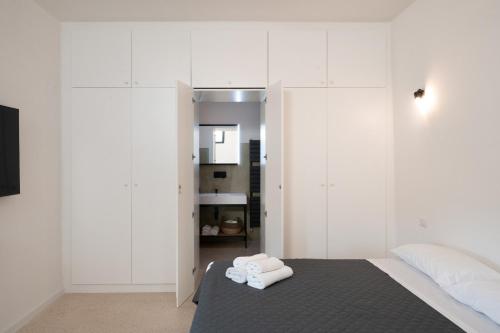 a bedroom with white walls and a bed with two towels at Suite Guagnano Luxury apartment in Nardò