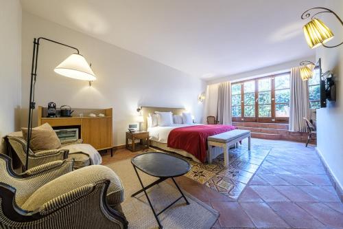 a bedroom with a bed and two chairs and a table at Hotel Mas La Boella in La Canonja