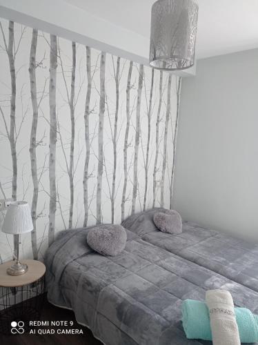 a bedroom with a bed with trees on the wall at Zapaterías in León