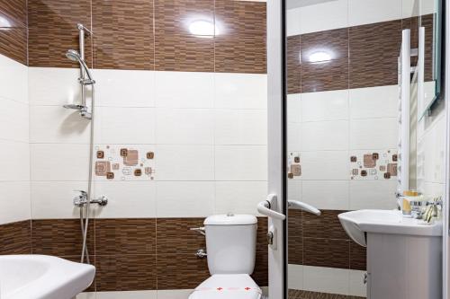 a bathroom with a toilet and a sink and a shower at Баня Аква Ризорт in Banya
