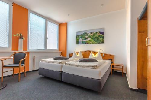 1 dormitorio con 1 cama, mesa y sillas en Hotel Weitblick Bielefeld en Bielefeld