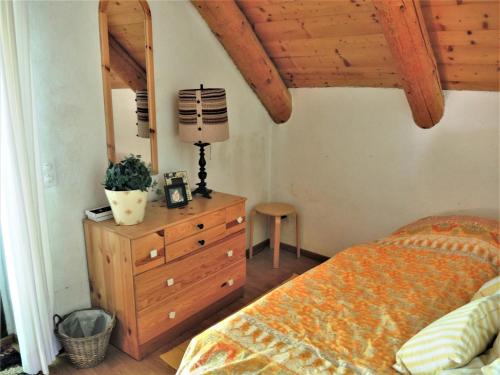 een slaapkamer met een bed en een dressoir met een lamp bij Rustico Gatto & Topolino in Agarone