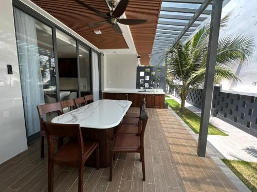 une cuisine avec une table et des chaises sur une terrasse dans l'établissement Oceanami Villa Long Hải - Vũng Tàu, à Long Hải
