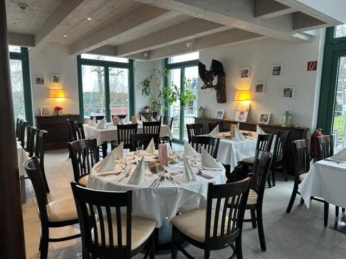 un comedor con mesas y sillas con mesas blancas en Auerhahn Nest en Bad Wildbad