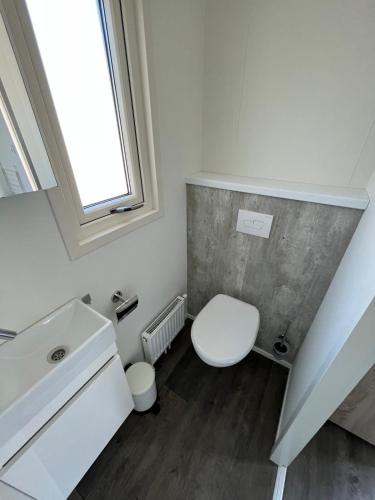 a bathroom with a white toilet and a sink at Chalet (A16) op gezellige familiecamping bij zee in Kamperland