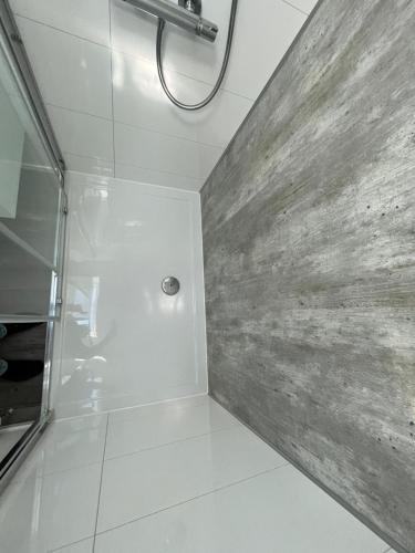 a bathroom with a shower with a stone wall at Chalet (A16) op gezellige familiecamping bij zee in Kamperland