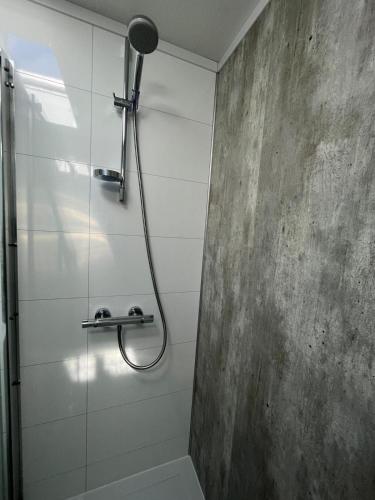a shower with a shower head in a bathroom at Chalet (A16) op gezellige familiecamping bij zee in Kamperland