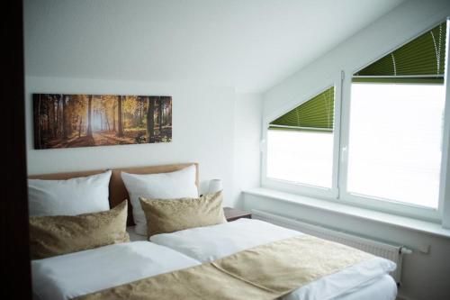 a bedroom with two beds and two windows at Auerhahn Nest in Bad Wildbad