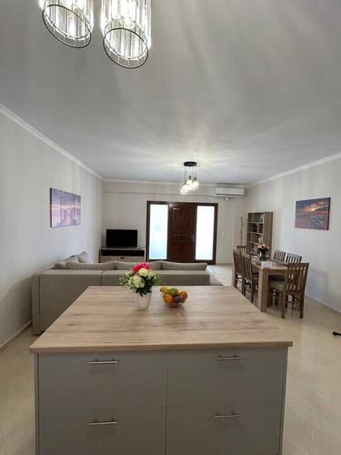 una cucina e un soggiorno con un tavolo con dei fiori sopra di Natti’s Apartment a Kontokali