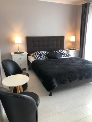 a bedroom with a bed and a table and chairs at Saviano Mare Villa in Międzyzdroje