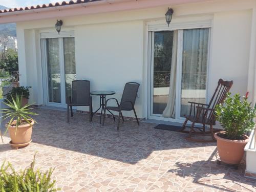 un patio con sedie, un tavolo e finestre di Ulmus Suite a Volos