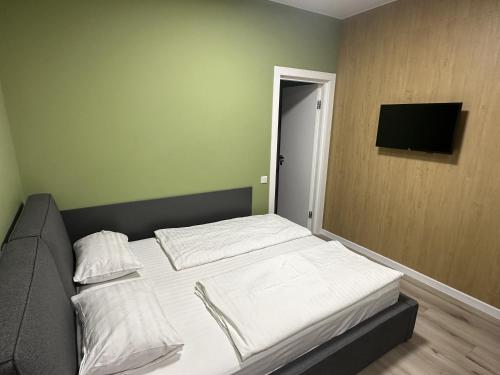 a bedroom with two beds and a television on the wall at irisHotels in Kyiv