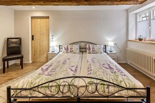 a bedroom with a large bed with purple flowers at Schmid am See in Gaienhofen