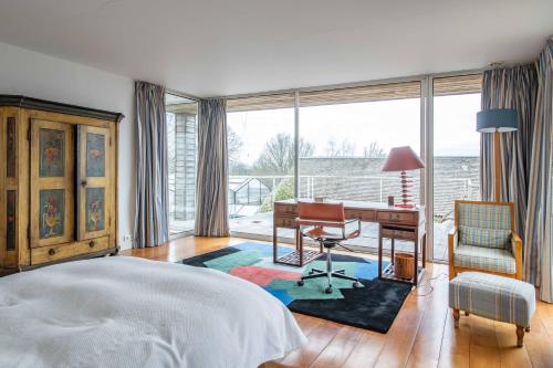 1 dormitorio con cama, escritorio y silla en Large contemporary house with indoor swimming pool, en La Gaudaine