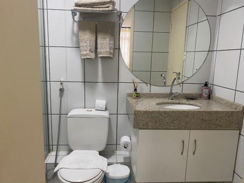 een badkamer met een toilet, een wastafel en een spiegel bij Gran Lençóis Flat Residence in Barreirinhas