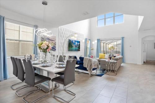 a dining room and living room with a table and chairs at Modern Resort House Pool Wi-Fi Minutes to Disney in Kissimmee