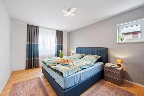 Un dormitorio con una cama azul con una mesa. en Minty Lounge en Ludwigshafen am Rhein