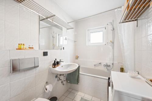 La salle de bains blanche est pourvue d'un lavabo et de toilettes. dans l'établissement Minty Lounge, à Ludwigshafen